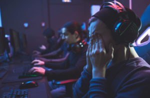 A young man rubbing his eyes after playing computer games