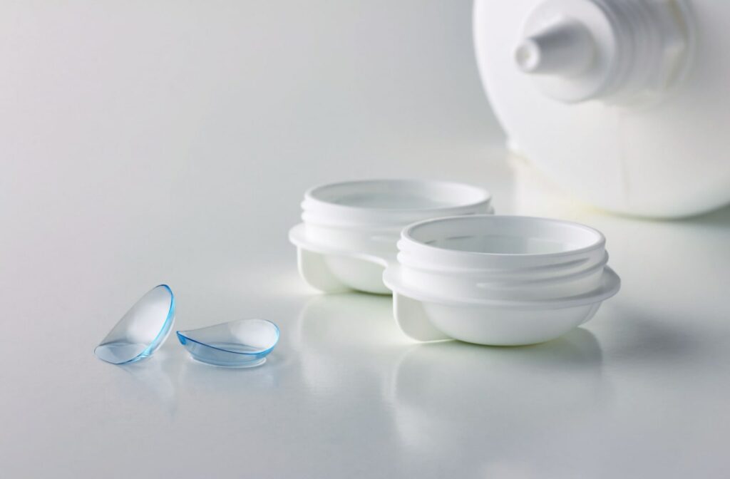 A pair of contact lenses, a case, and a bottle of solution on white background