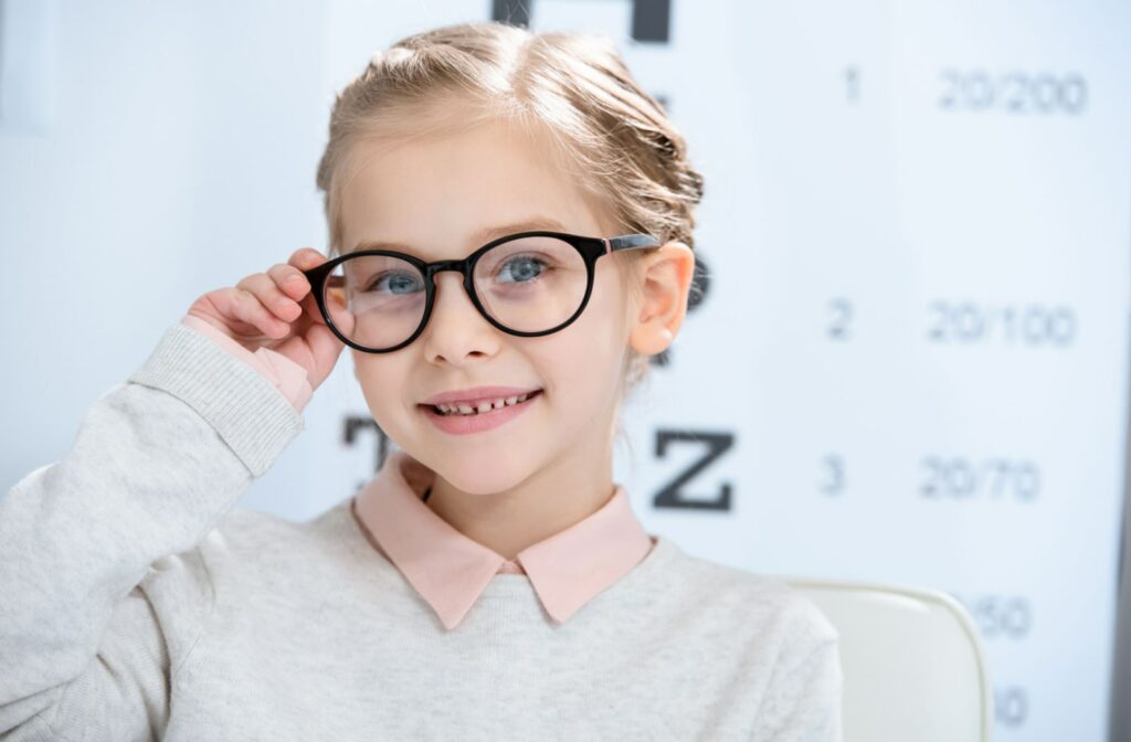 A young girl smiling and wearing glasses to control myopia progression in her vision