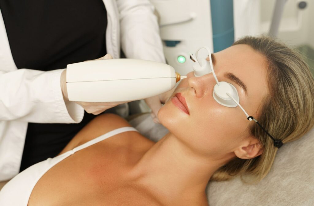 An optometrist treats a female patient's dry eye disease with IPL therapy