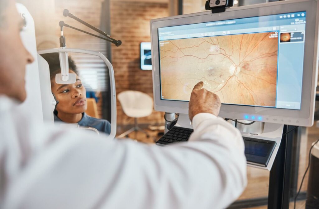 A male optometrist showing a female patient an image of her retina through optical coherence tomography.