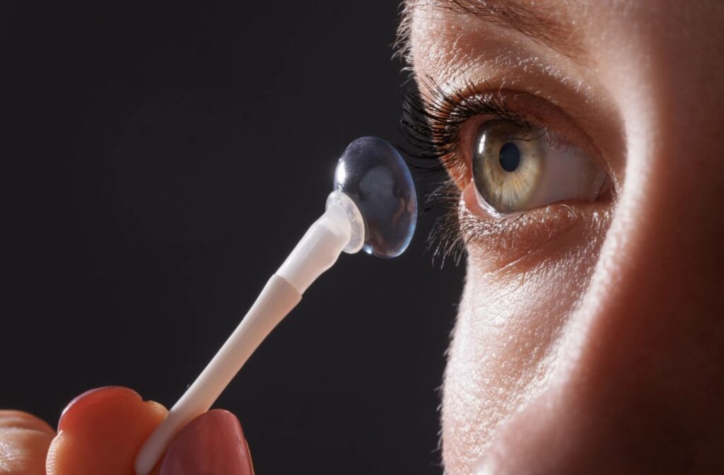 A close up of a woman applying prescription contact lenses for her astigmatism.