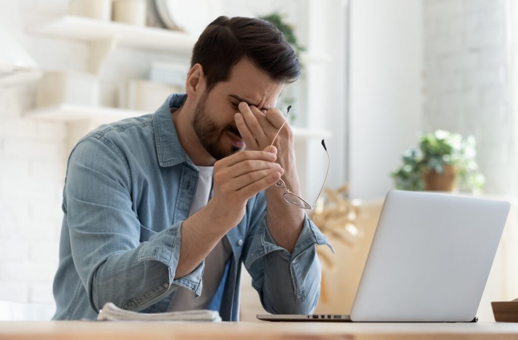 Man experiencing eye discomfort and dryness due to stress.