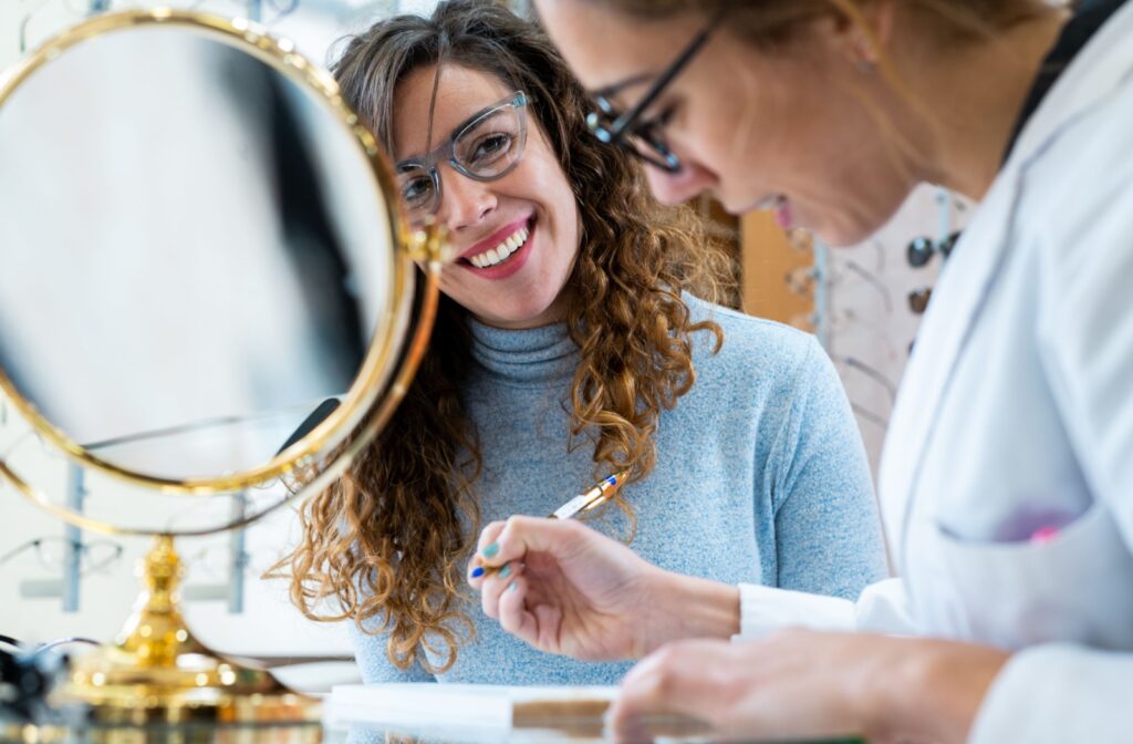 An eye doctor helps their patient fill out paperwork for their vision insurance coverage.