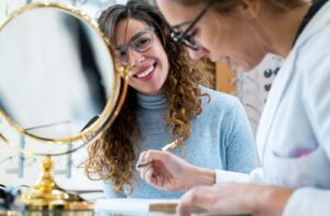 An eye doctor helps their patient fill out paperwork for their vision insurance coverage.