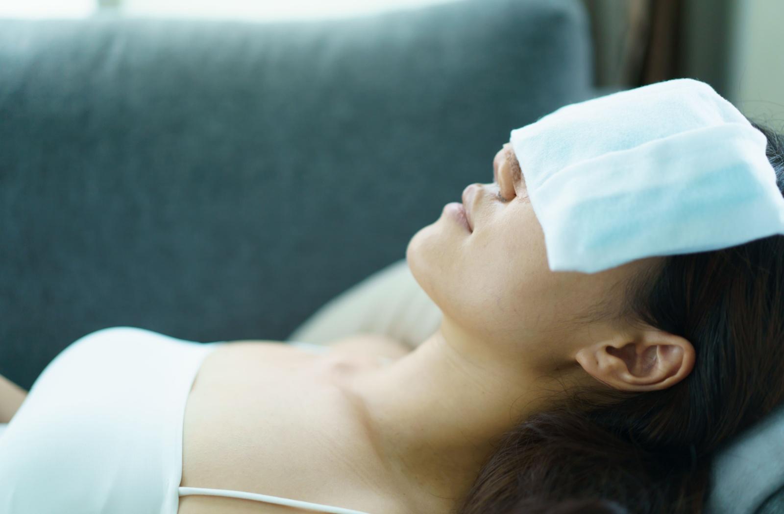 Patient resting with a warm compress over her eyes to help relieve dry eye symptoms.